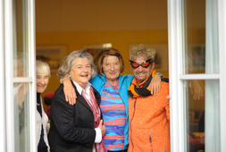 Eine Gruppe Senioren schauen beim Fenster hinaus | © Caritas München und Oberbayern